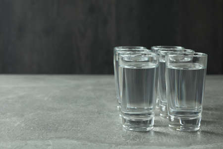Shots with vodka on gray background, space for textの写真素材