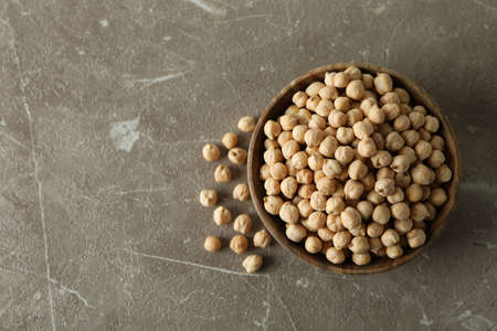 Wooden bowl with fresh chickpea on gray tableの写真素材