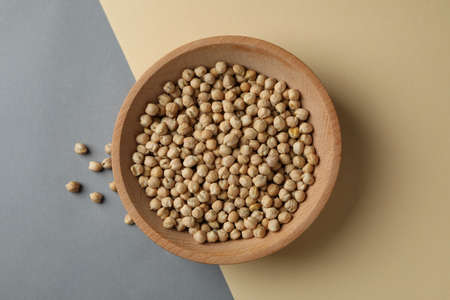 Wooden bowl with fresh chickpea on two tone backgroundの写真素材