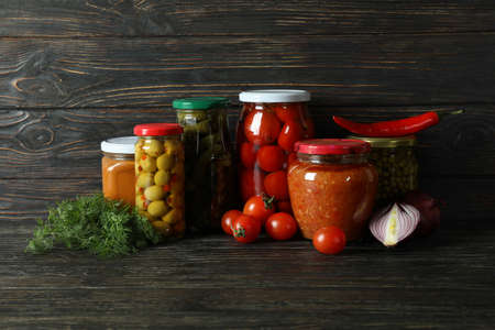 Jars with different canned food on wooden backgroundの写真素材