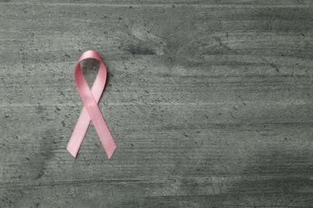 Pink awareness ribbon on gray textured backgroundの写真素材