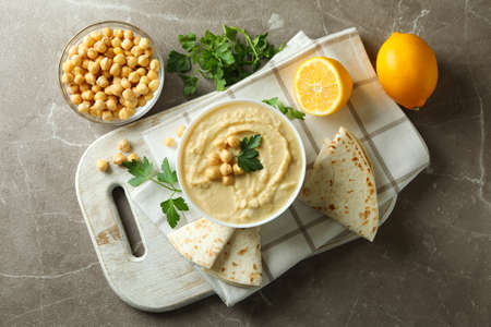 Concept of tasty eat with bowl of hummus on gray backgroundの写真素材