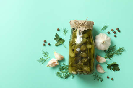 Jar of pickled cucumbers and ingredients on mint backgroundの写真素材