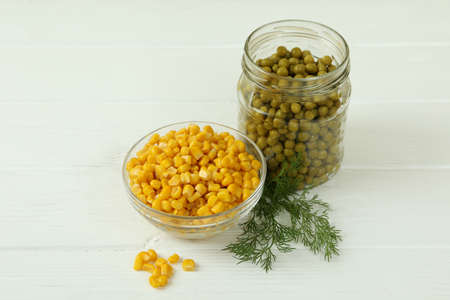 Canned peas and corn on white wooden backgroundの写真素材