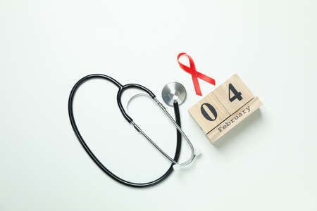 Red awareness ribbon, stethoscope and 4 february on white backgroundの写真素材