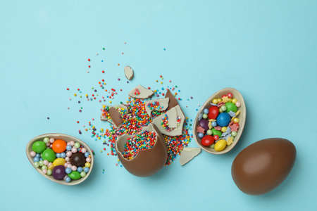 Easter chocolate eggs with sprinkles and candies on blue backgroundの写真素材