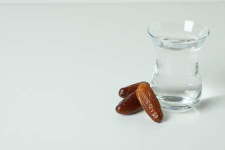 Glass of water and dates on white backgroundの写真素材