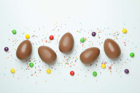 Easter chocolate eggs, candies and sprinkles on white backgroundの写真素材