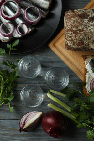 Shots of vodka and tasty snacks on wooden table, top viewの写真素材