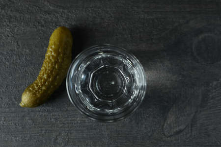 Shot of vodka and pickle on dark backgroundの写真素材