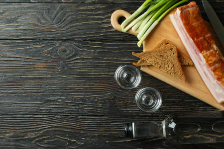 Vodka, onion, bacon and bread on wooden backgroundの写真素材