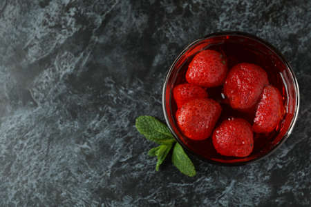 Glass of strawberry jelly on black smokey tableの写真素材