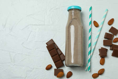 Bottle of milkshake, almond, chocolate and straws on white textured backgroundの写真素材
