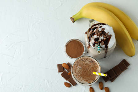 Concept of delicious food with chocolate milkshake and banana on white textured tableの写真素材