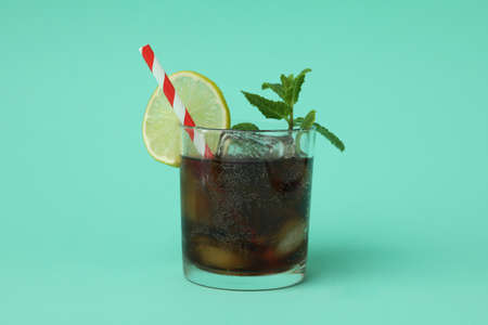 Glass of Cuba Libre cocktail on mint backgroundの写真素材