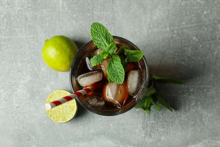 Glass of Cuba Libre and ingredients on gray backgroundの写真素材