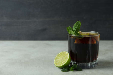 Glass of Cuba Libre on white textured table