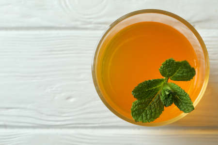 Glass of orange jelly with mint on white wooden tableの写真素材