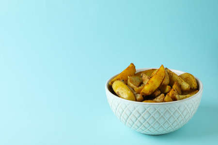 Bowl of potato wedges on blue backgroundの写真素材