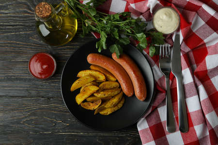 Concept of tasty meal with potato wedges on wooden backgroundの写真素材
