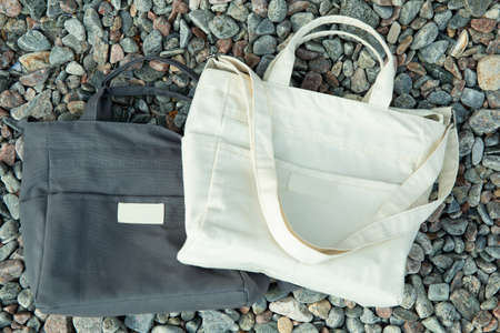 Stylish blank eco bags outdoor on pebblesの写真素材