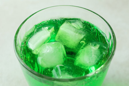 Glass of green soda on white textured background, close upの写真素材