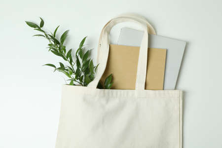 Eco bag with copybooks and twig on white backgroundの写真素材