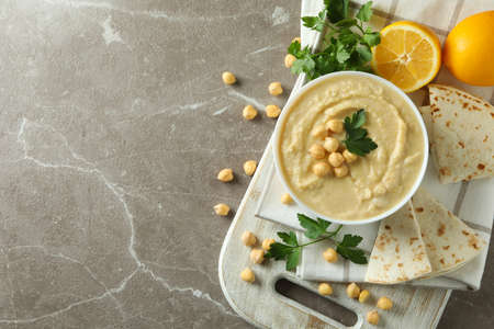 Concept of tasty eat with bowl of hummus on gray backgroundの写真素材