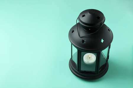 Black lantern on mint background, space for textの写真素材
