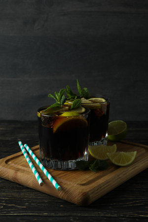 Board with glasses of Cuba Libre on wooden background