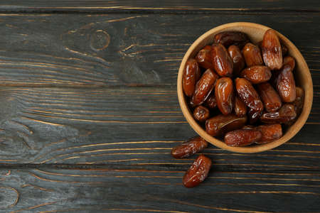 Bowl with dried dates on wooden tableの写真素材