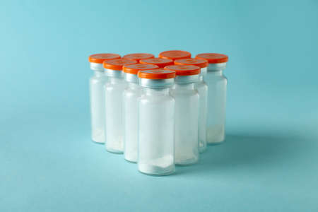Vials with powder vaccine on blue backgroundの写真素材