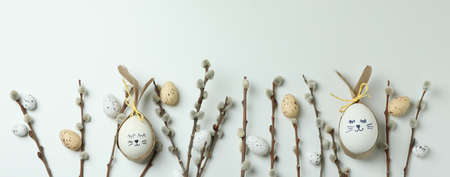 Easter eggs, quail eggs and catkins on white background