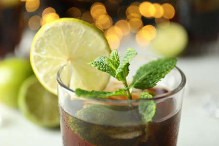 Glass of Cuba Libre against blurred lights, close upの写真素材