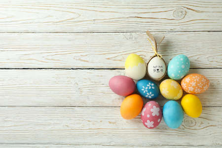 Bunny made of egg and Easter eggs on wooden background