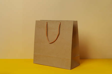 Blank paper bag against beige background, space for textの写真素材