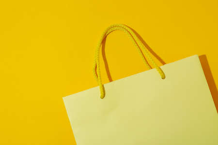 Blank paper bag on yellow background, space for textの写真素材