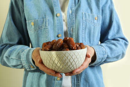 Woman in jeans shirt hold bowl of dates