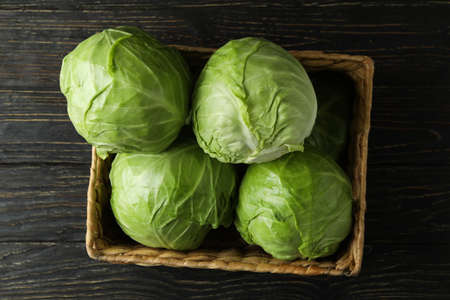 Basket with fresh cabbage on wooden tableの写真素材