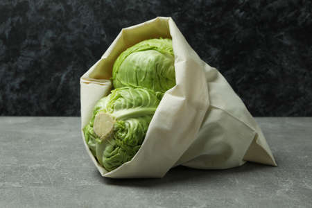 Bag with fresh green cabbage on gray tableの写真素材