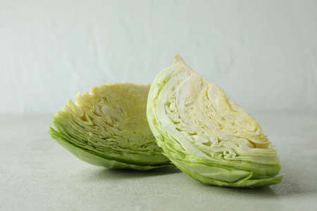 Fresh green cabbage on white textured table