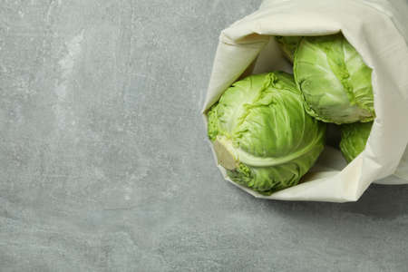 Bag with fresh green cabbage on gray tableの写真素材