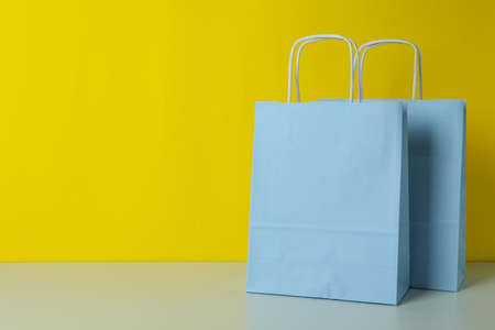 Blank paper bag against yellow background, space for textの写真素材