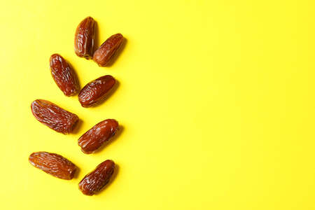 Tasty dried dates on yellow background, space for textの写真素材