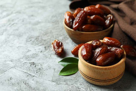 Bowls of dried dates and kitchen napkin on gray textured backgroundの写真素材