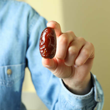 Woman in jeans shirt hold date fruitの写真素材