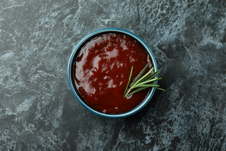 Bowl of barbecue sauce on black smoky backgroundの写真素材