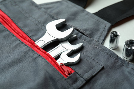 Overalls with wrenches on light gray background, close upの写真素材