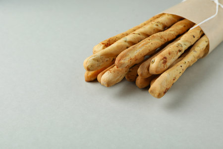 Craft paper with grissini breadsticks on light gray backgroundの写真素材