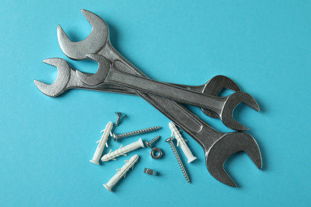 Wrenches and dowels on blue background, top view